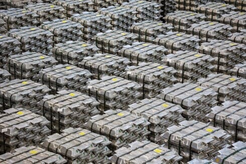 Aluminum ingot bar stacked in warehouse. Raw material for industrial concept. General cargo warehouse concept